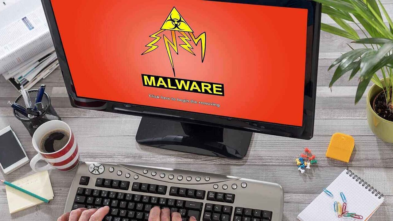 man using a computer with malware concept on the screen